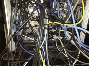 An ugly tangle of wires in the back of a rack